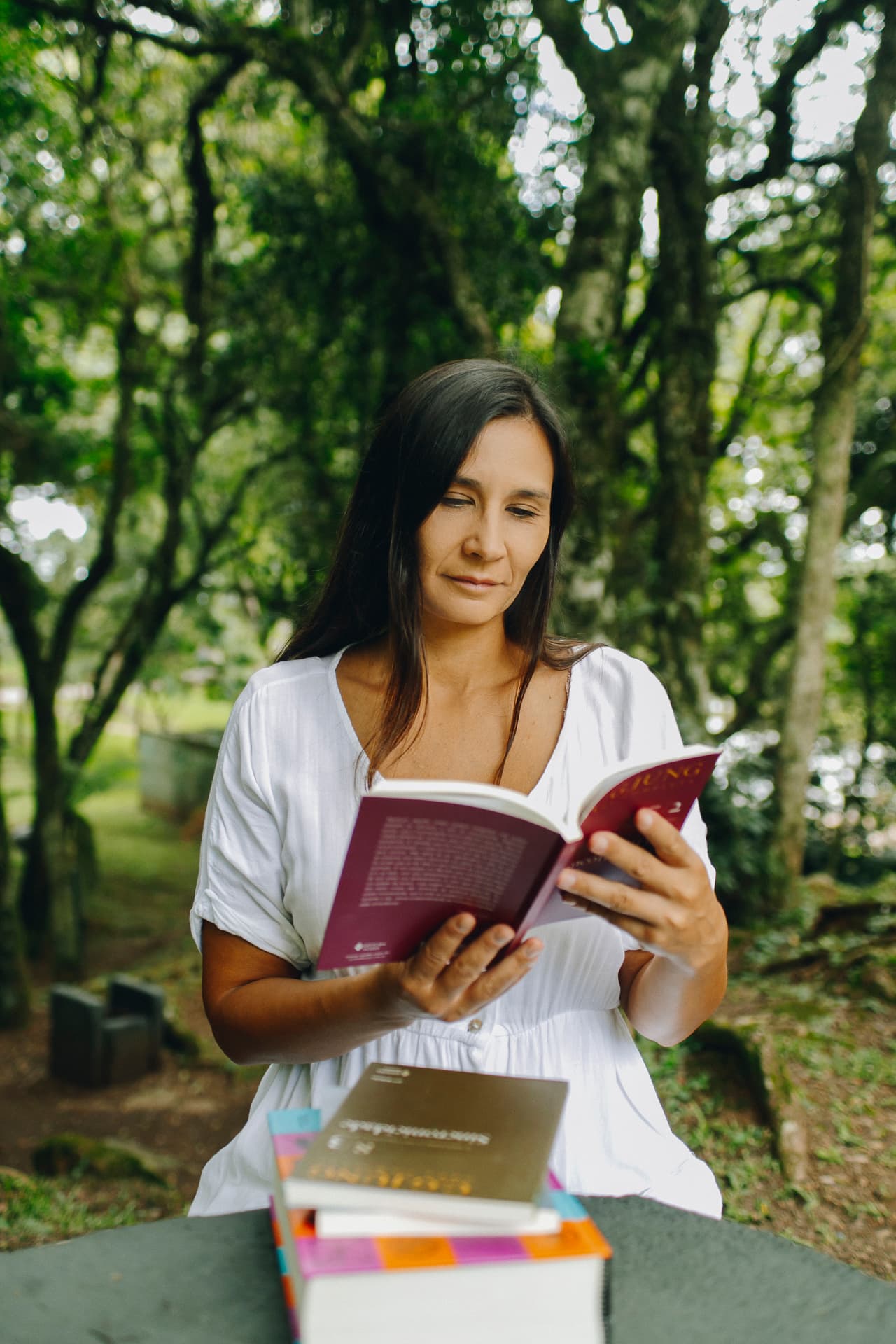 Bruna Magno lendo um livro ao ar livre