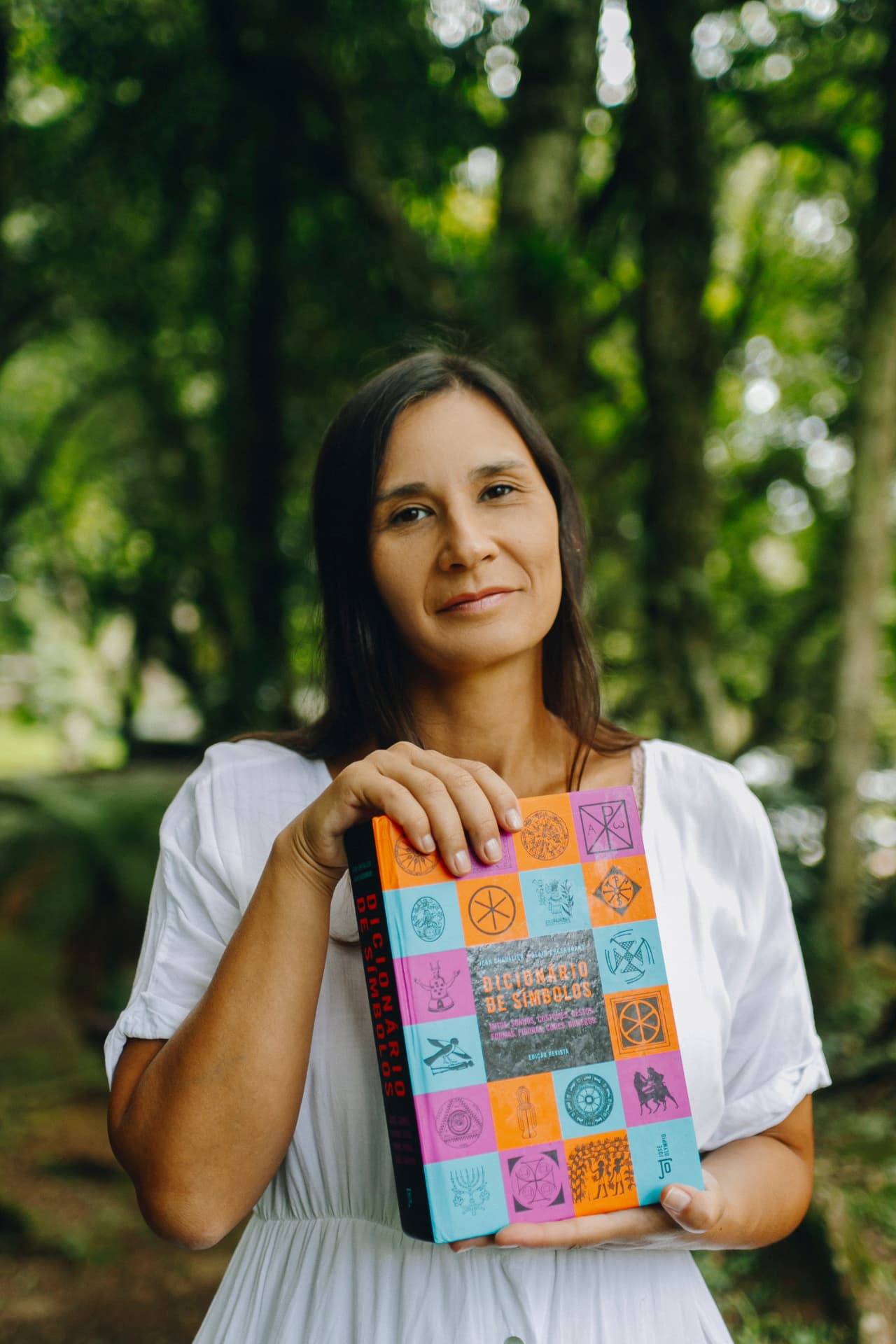 Bruna Magno segurando um dicionário de símbolos