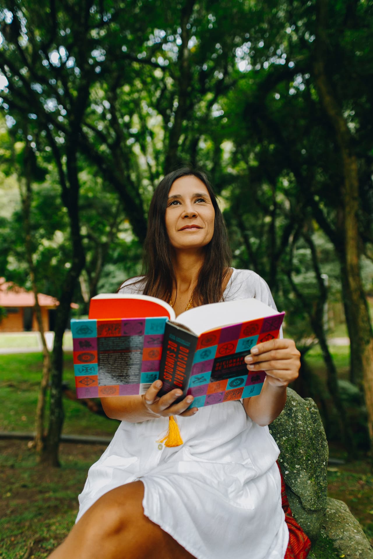 Bruna Magno lendo um livro sobre símbolos